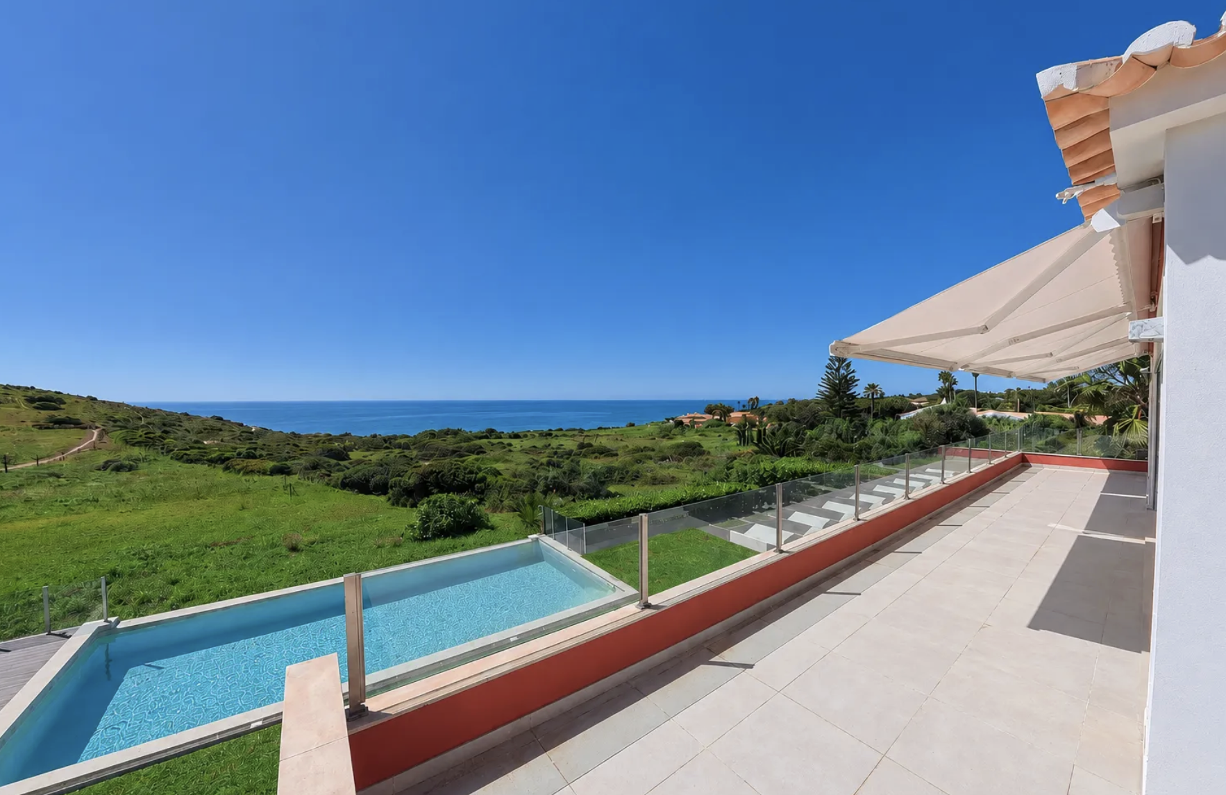 Sea front villa for sale at Praia da Luz, Algarve — pool terrace with Atlantic ocean views